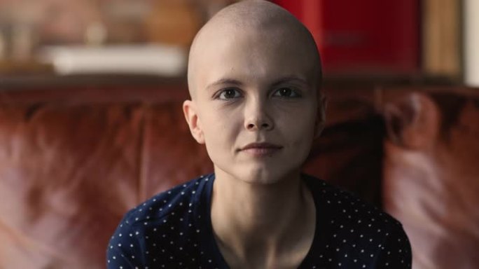 女性癌症患者看着相机感到乐观微笑