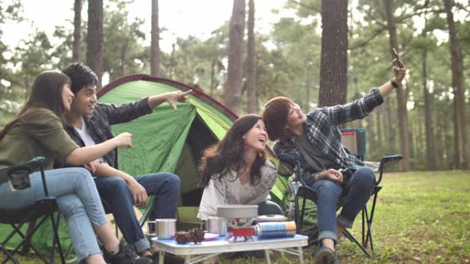 一群年轻的亚洲朋友露营在森林里一起拍照