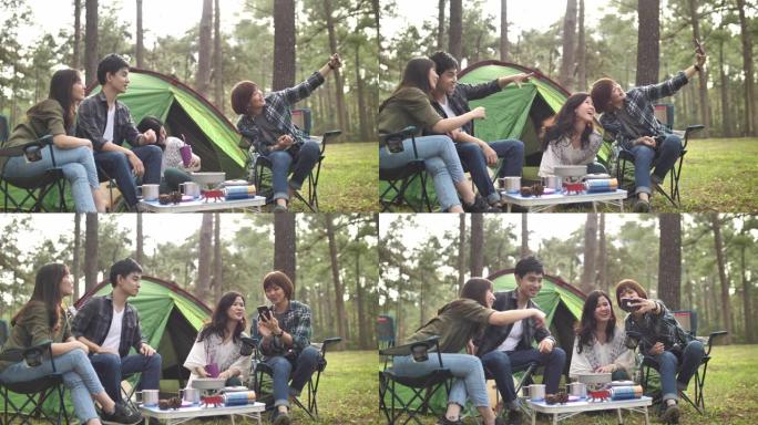 一群年轻的亚洲朋友露营在森林里一起拍照