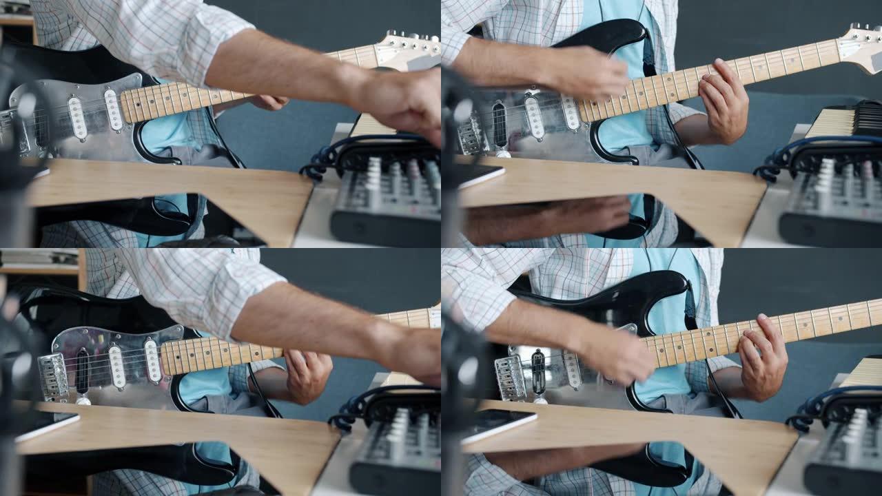使用混音设备进行手部特写，然后在音乐家在工作室中练习时弹奏电吉他