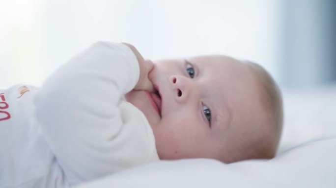 一个可爱的男婴在家床上的4k视频片段
