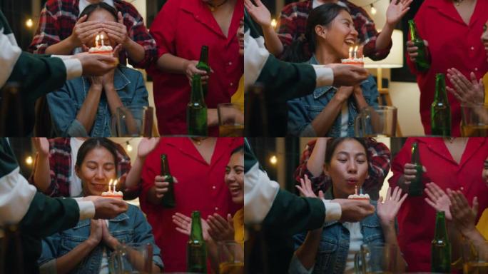 一群年轻的亚洲朋友惊讶于生日蛋糕、喝酒精啤酒和有趣的笑声，在夜生活室内享受聚会。