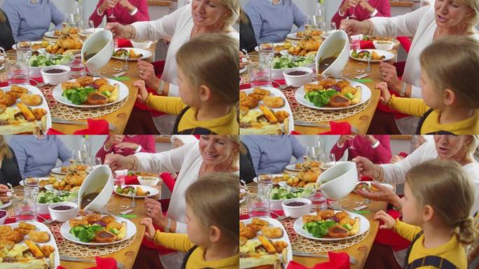 当多代家庭吃圣诞大餐时，祖母将肉汁倒在孙女的食物上