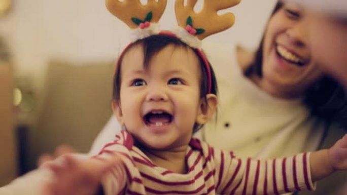 圣诞节期间，亚洲家庭在客厅一起玩。