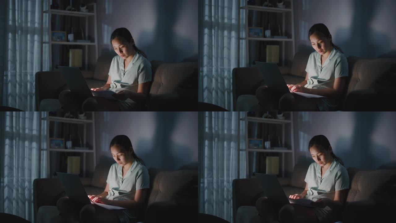 亚洲妇女晚上在家工作和使用笔记本电脑