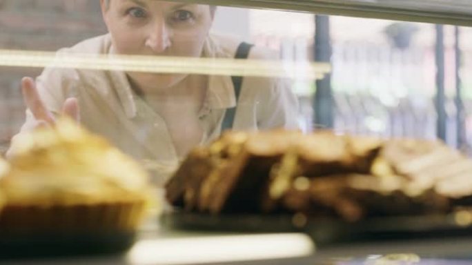 一个成熟女人在面包房挑选食物的4k视频