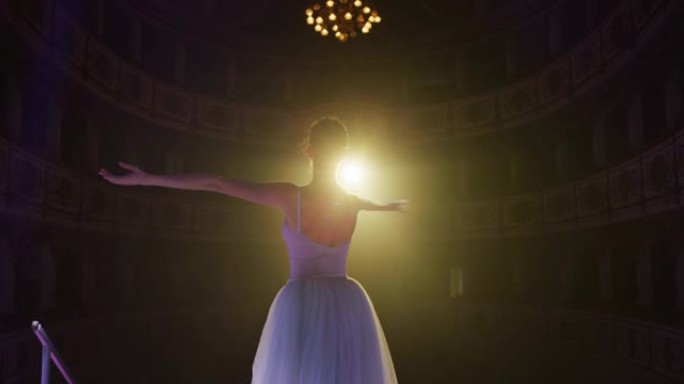 穿着白色芭蕾舞短裙和脚尖鞋的年轻优雅古典芭蕾舞女舞者的电影镜头将在经典剧院舞台上放映，并在演出开始前