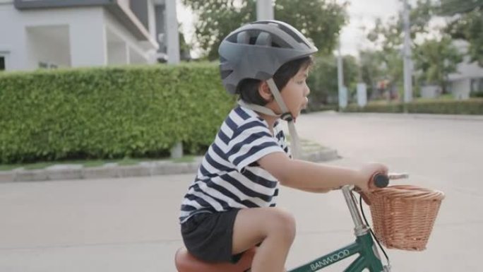 男孩骑自行车。街道上踩脚踏车的孩子歪歪扭