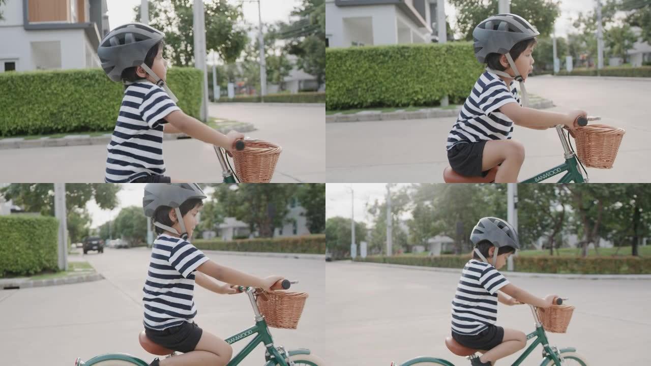 男孩骑自行车。街道上踩脚踏车的孩子歪歪扭