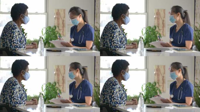 女医生与年长病人在门诊预约时戴口罩