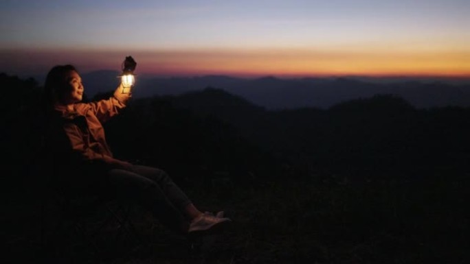 女人在日落时在大自然中的山上放松