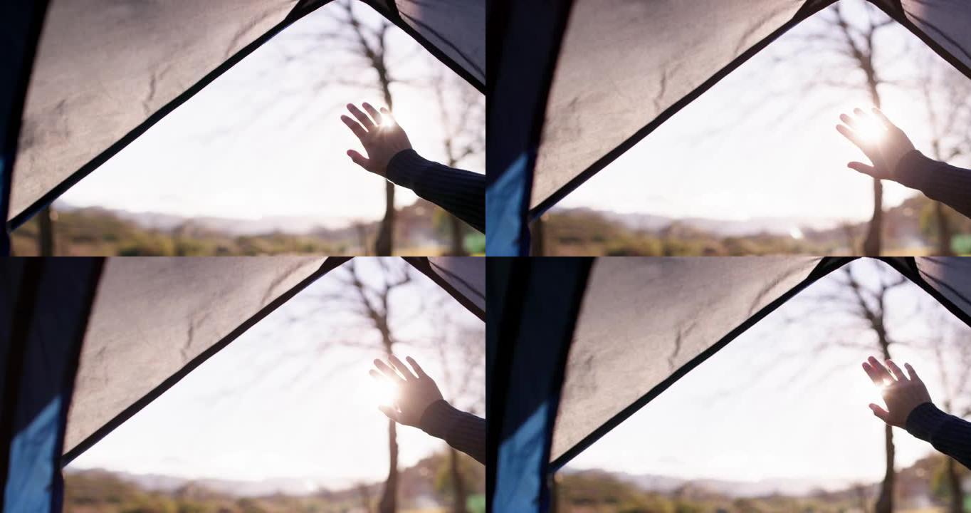 4k视频片段，一名妇女从帐篷内举手向太阳