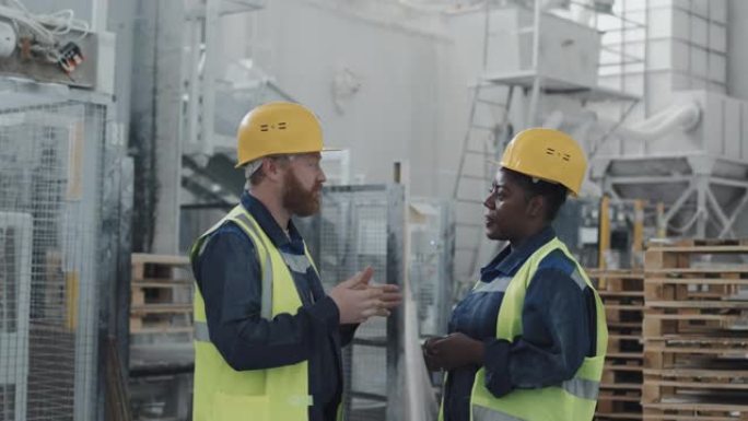 种族多元化的工厂工人讨论某些事情