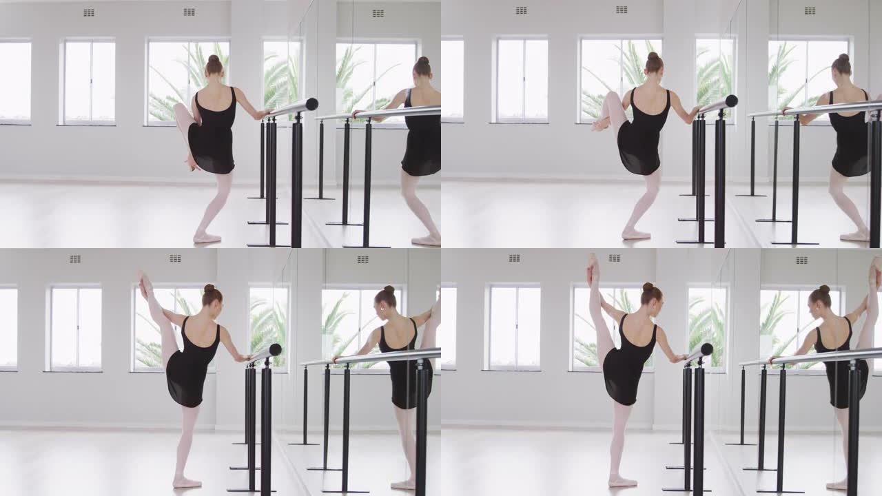 在明亮的工作室里，白人女芭蕾舞演员在镜子前伸展