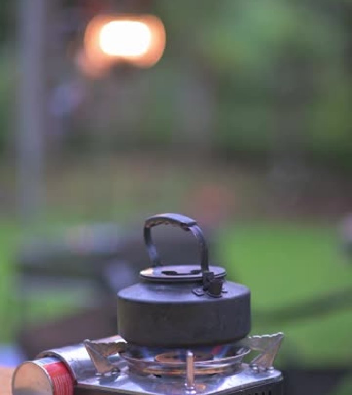 野营炉热水壶早上在野餐桌上沸腾