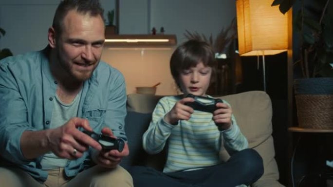 快乐的30多岁的年轻成年父亲玩游戏机玩得很开心，在家里输给了可爱的十几岁的男孩儿子。