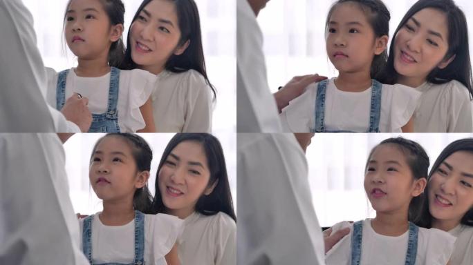 亚洲6岁小女孩的幸福坐在医院与亚洲儿科医生男性交谈。医生和病人的咨询理念。