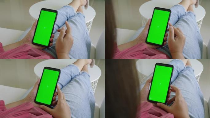 女人拿着色键绿屏智能手机看内容