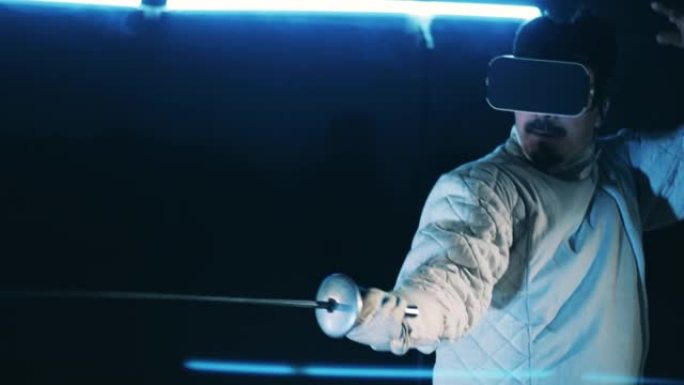 男运动员戴着VR设备练习击剑技巧。虚拟现实，增强现实游戏概念。