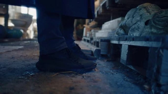 男性陶瓷陶工鞋特写镜头朝着泥塑工作室的架子移动