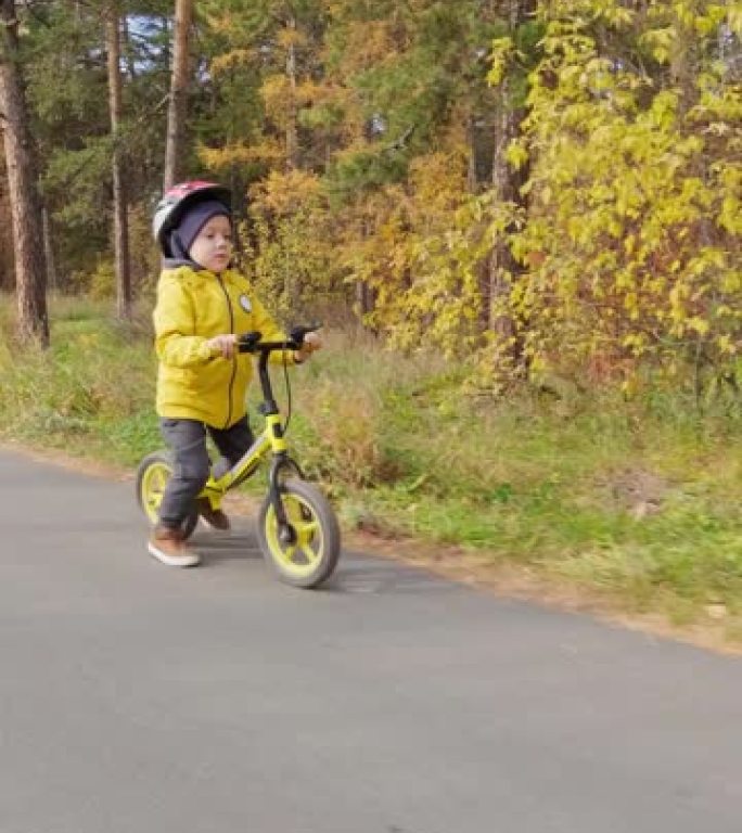 男孩骑平衡自行车的垂直慢速