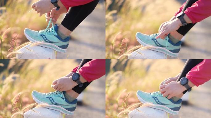 女人系好运动鞋准备在早上跑步