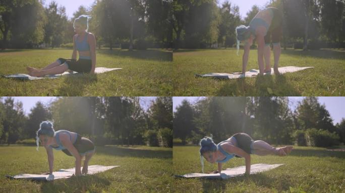 一个有绿松石头发的健康美女正在公园的瑜伽垫上做平衡运动