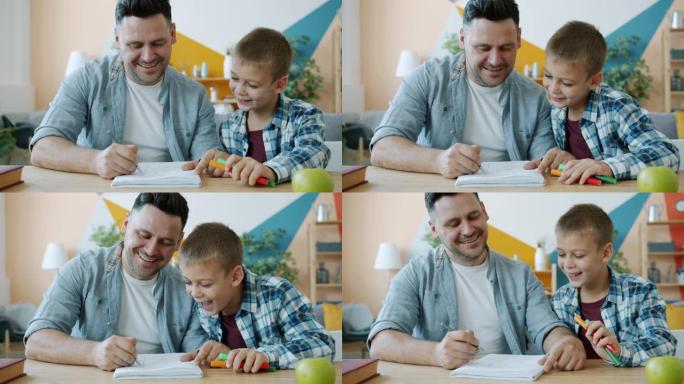 开朗的爸爸在家里的办公桌上为快乐的孩子画有趣的照片