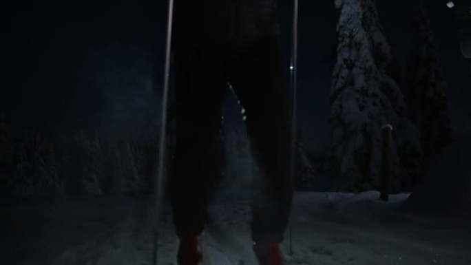 SLO MO两名男子越野滑雪运动员在夜间带大灯的赛道上滑雪