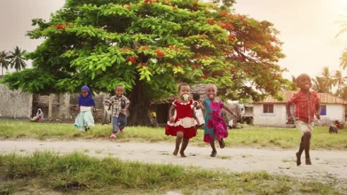 一群非洲小孩奔向镜头，在乡村大笑。充满生活和快乐的黑人孩子享受他们的童年和一起玩。笑容灿烂的小脸
