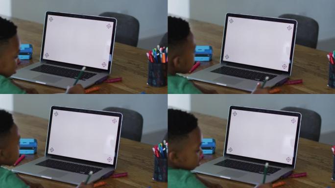非裔美国男孩在家里做作业时在笔记本电脑上进行视频通话，并带有复印空间