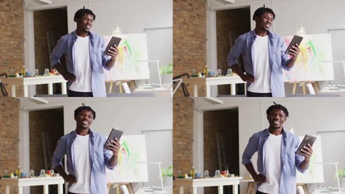 非裔美国男艺术家在art studio的数字平板电脑上进行视频通话时微笑着