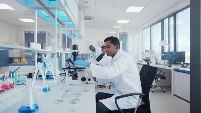 现代医学研究实验室: 使用显微镜，分析生化样品的科学家组成的多元化团队。医学科学实验室，微生物学发展