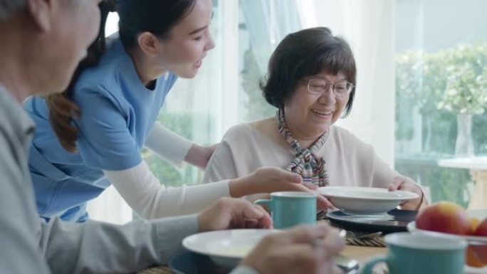 迷人的年轻亚洲老年公民夫妇在老年亚洲护理家庭护理中的日常生活方式中，早上在家里的餐桌上快乐地坐，聊天