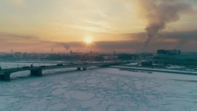 在寒冷的冬天的傍晚，从河边有很多冰雪的地方，在圣彼得堡的日落空中俯视