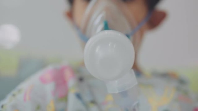 小男孩在医院用喷雾器吸气。