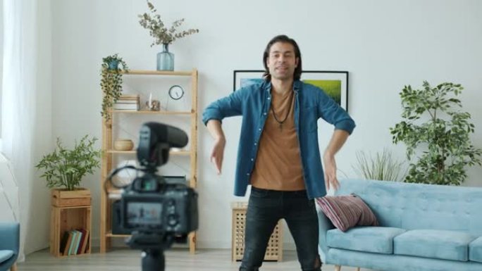 快乐的男人舞者展示时髦的舞蹈动作，为在线博客录制视频