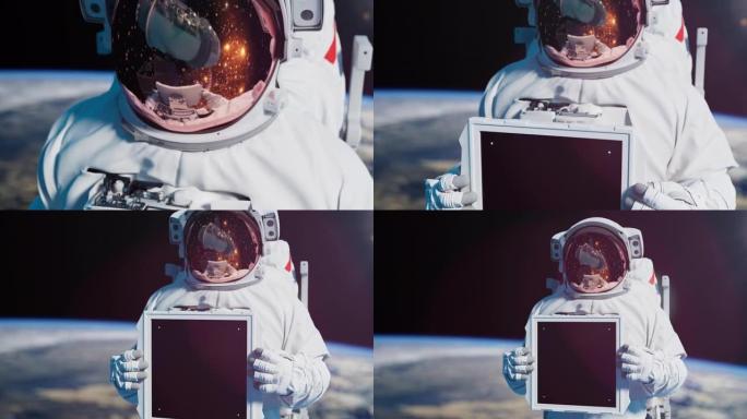 宇航员举着铭文的标志。太空人在外层空间拿着带有色度键的屏幕对着地球