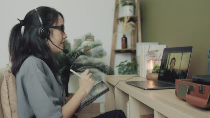 亚洲自由职业者智能商务女性休闲服使用笔记本电脑在家工作。