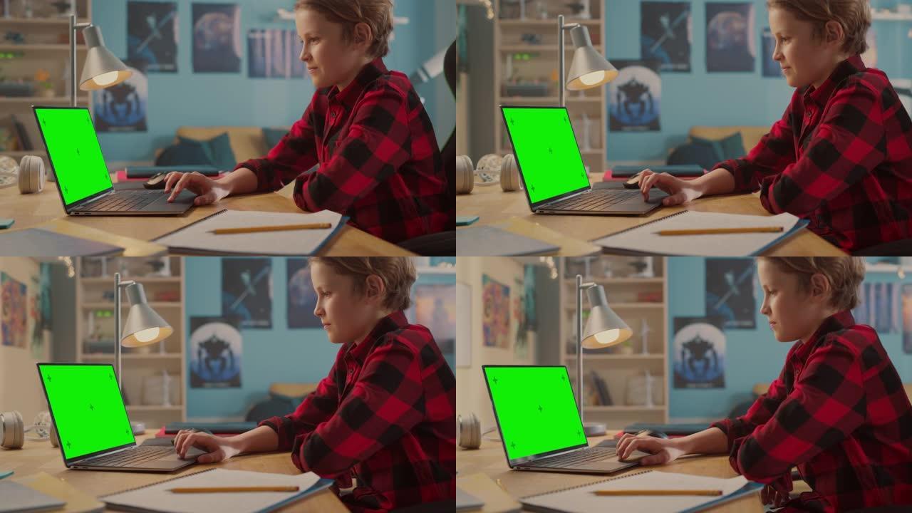 聪明的小男孩在带有绿色色度键屏幕显示模型的笔记本电脑上研究作业。青少年浏览教育研究，在社交媒体上聊天