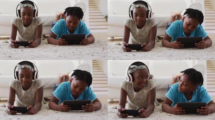非裔美国人兄弟姐妹在家中使用电子设备躺在地板上