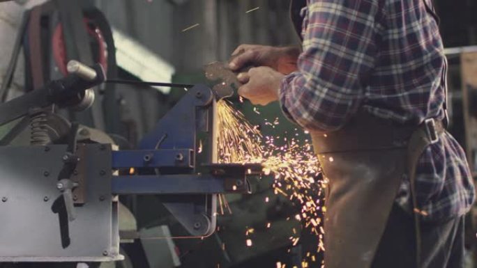 带火花砂光机上的男性铁匠造型金属制品设计