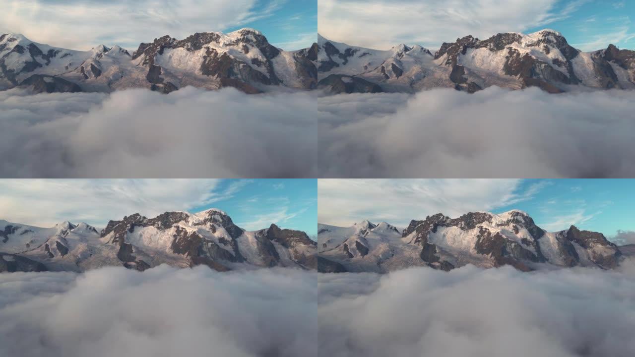 瑞士阿尔卑斯山高雪山的空中拍摄在日出时间的云层上方移动拍摄