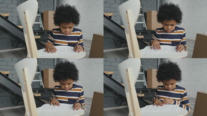 黑人男孩阅读组装椅子的说明