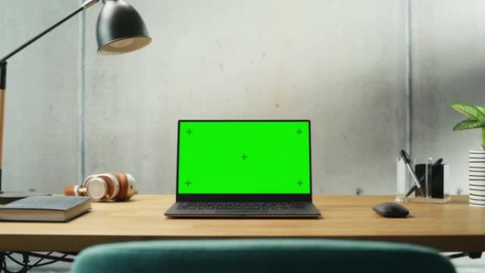 笔记本电脑，模拟绿屏显示站在桌子上。高效简约的现代办公空间设计，保证和谐与生产力。色度键监视器。缩小