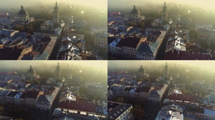 飞越乌克兰利沃夫市中心。利沃夫阳光明媚的雾蒙蒙的早晨。市场广场，天主教大教堂和老房子的空中拍摄