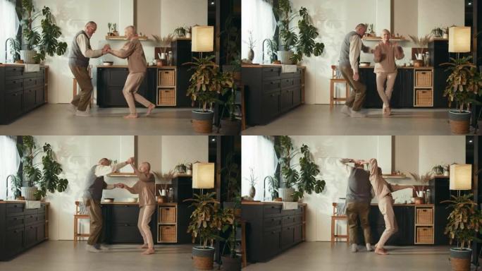 忠诚概念。快乐甜蜜65-70岁的高级男人和女人一起跳舞，在舒适的厨房里大笑。