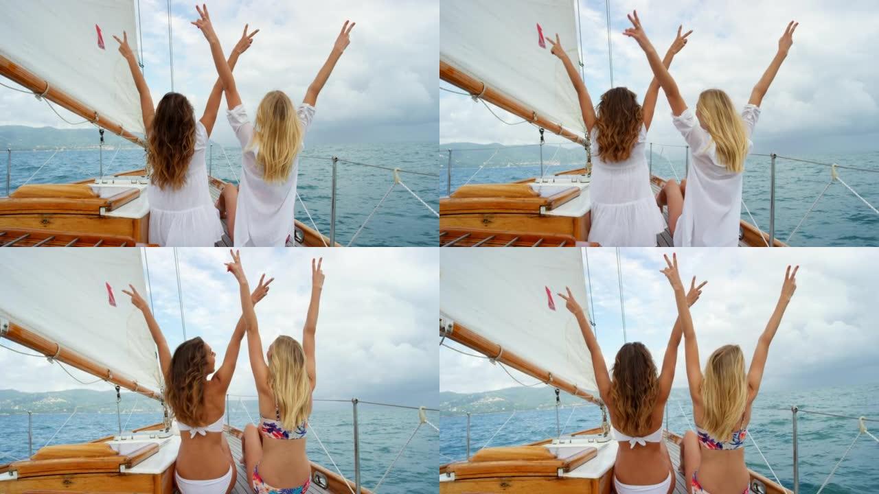 无忧无虑的年轻女性在乘船游览时做着和平标志。两个快乐的年轻朋友在意大利海洋上航行，在和平标志上玩耍。