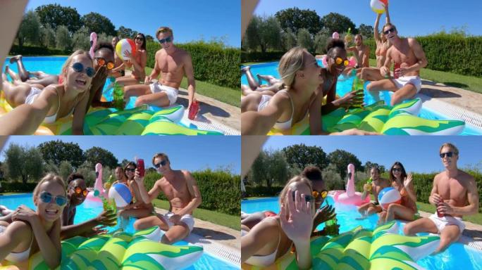 穿着泳装的年轻多民族朋友的真实照片是在五颜六色的充气设备上放松，并在阳光明媚的日子里用智能手机在游泳