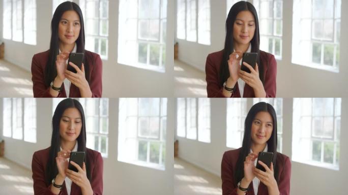 亚洲女商人在社交媒体上研究想法，在手机上发短信。企业家独自站立并使用技术进行网络，浏览互联网并与客户